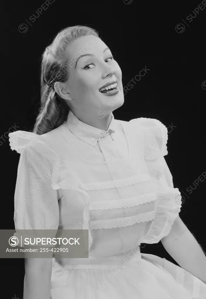 Studio portrait of young woman laughing.