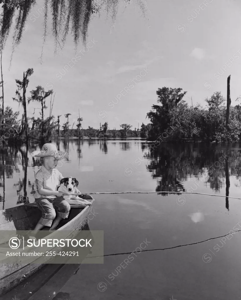 Boy fishing with dog by side