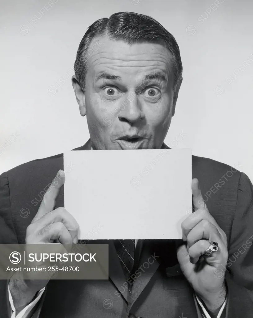 Portrait of a businessman holding a blank placard