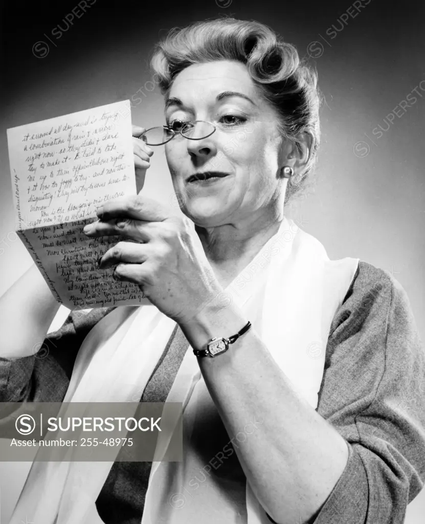 Studio shot of woman reading letter