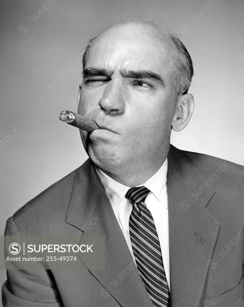 Studio portrait of man smoking cigar