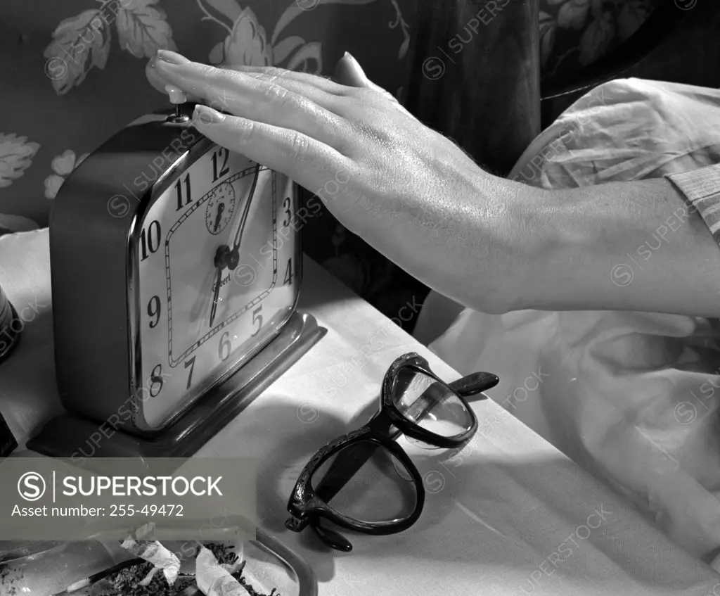 Hand turning off alarm clock