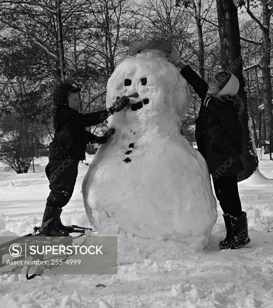 Two boys making snowman