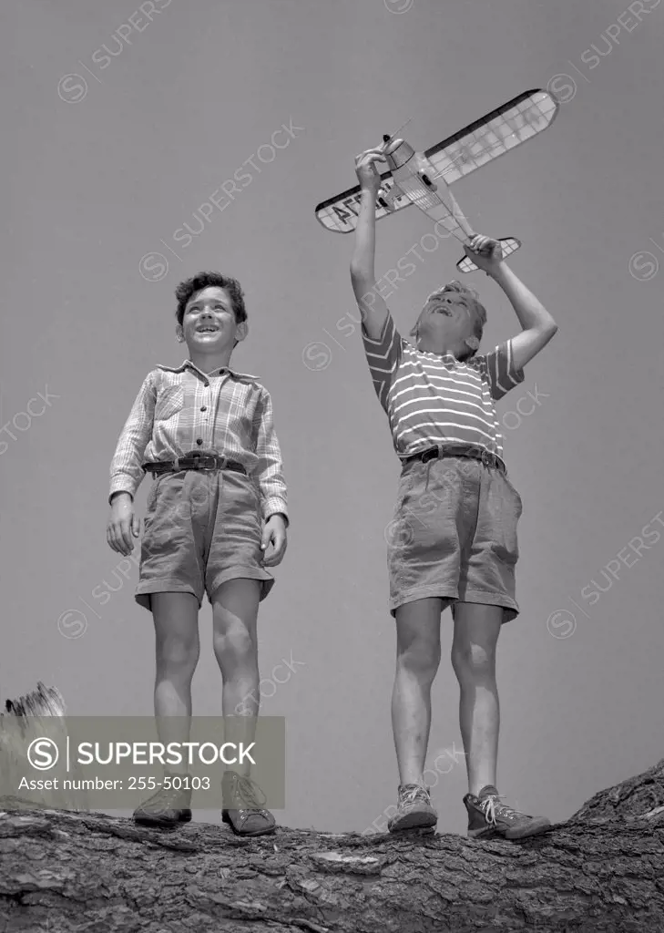 Boys playing with model airplane