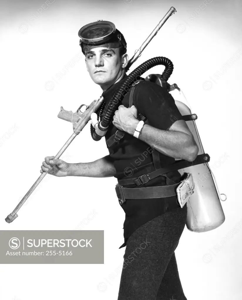 Scuba diver carrying oxygen tank and speargun