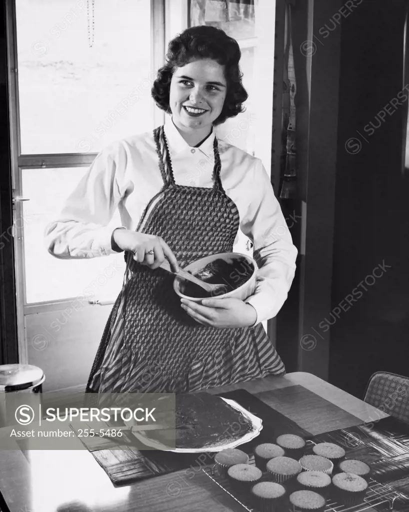 Young woman mixing chocolate in a bowl and smiling