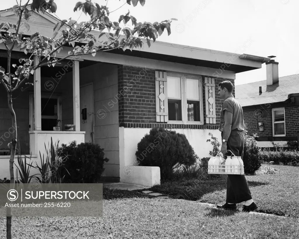 Side profile of a milkman delivering milk