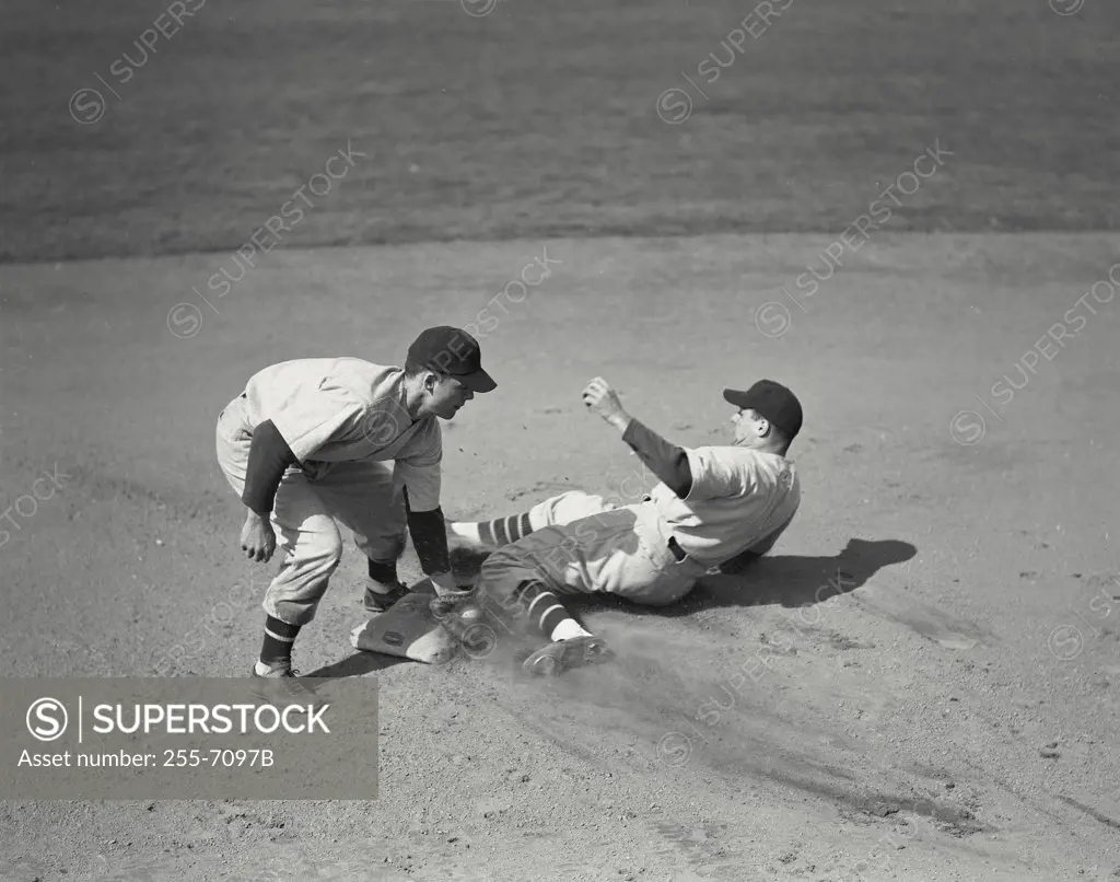 Baseball player tagging out runner sliding into base