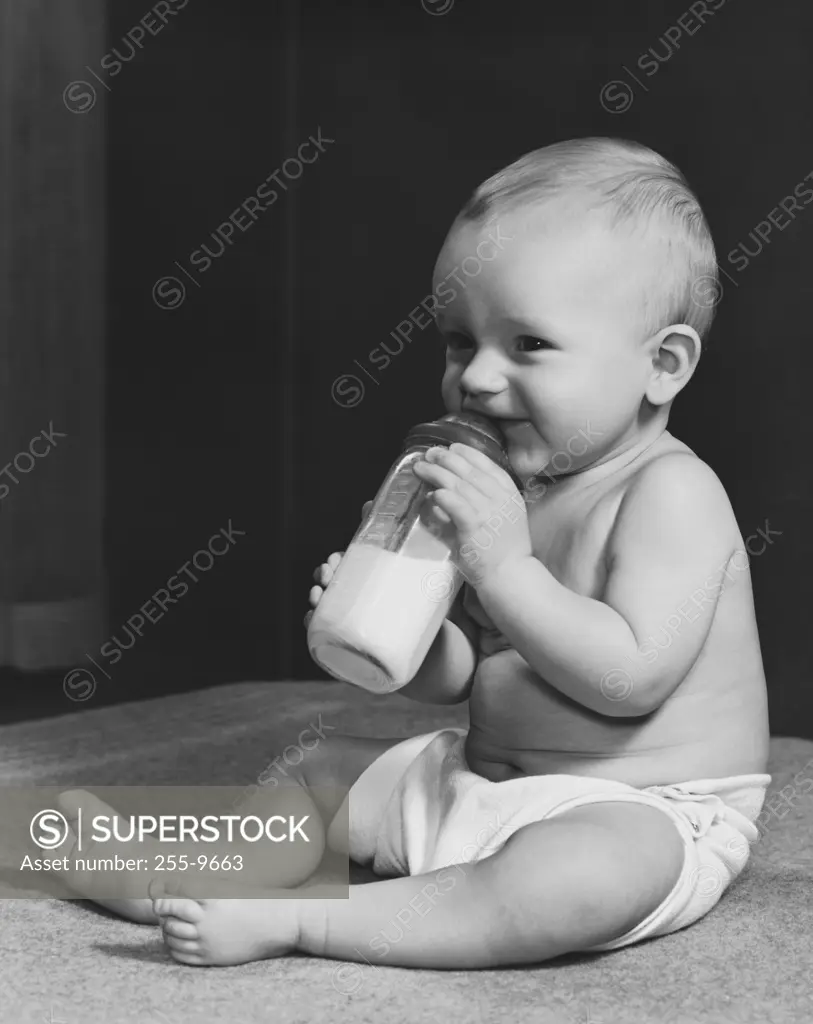 A baby drinking from a baby bottle