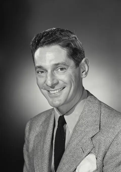 Vintage Photograph. Happy brunette man wearing blazer and tie smiling