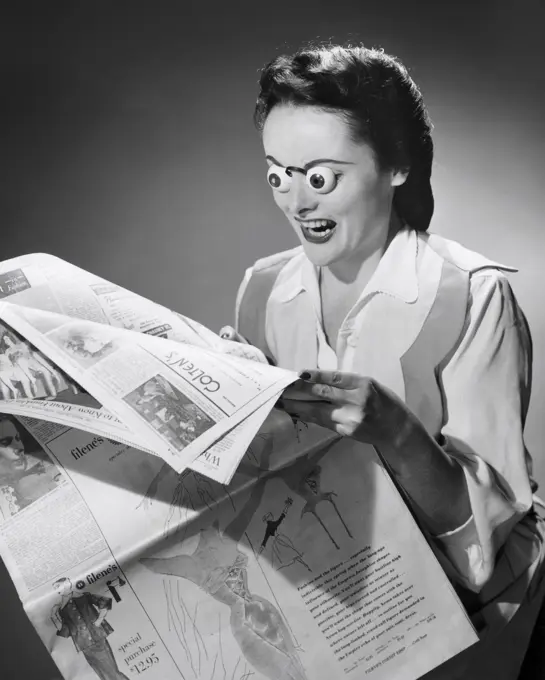 Young woman reading a newspaper with her eyes popping out