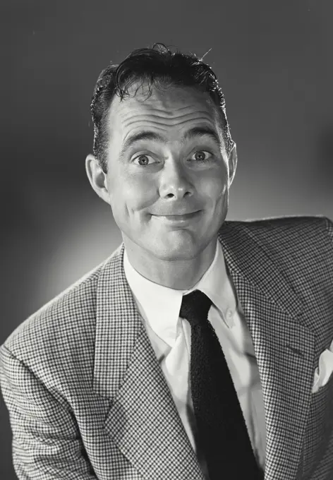 Portrait of man in suit and tie smiling.