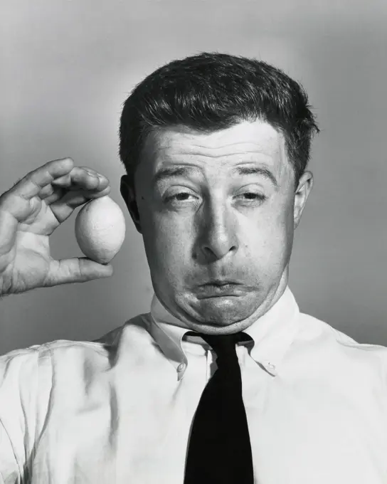 Close-up of a businessman holding a lemon and making a funny face