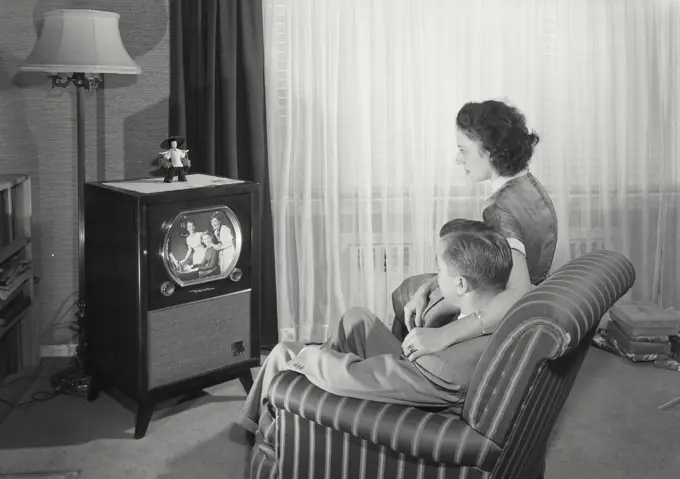 Vintage Photograph. Man and Wife sitting in chair wtching television