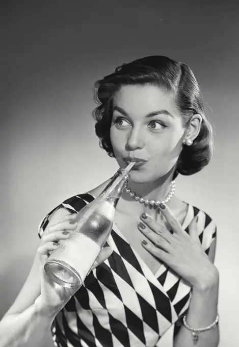 Vintage Photograph. Model in checkered blouse sipping drink through straw