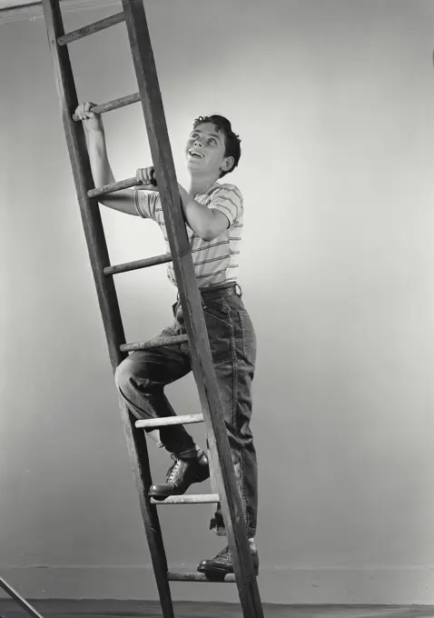 Vintage photograph. Boy smiling climbing wooden ladder