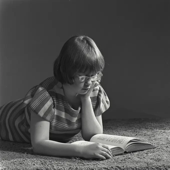 Vintage Photograph. Young girl reading a book. Frame 1