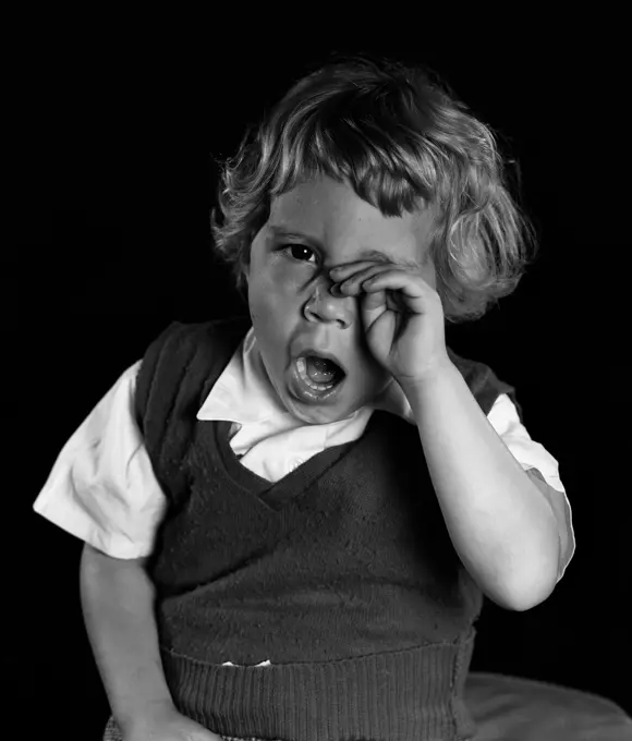 Studio portrait of boy yawning