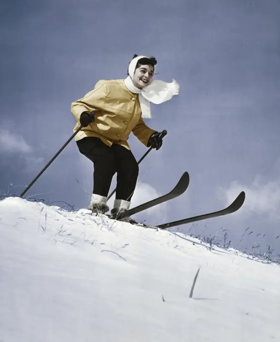 Low angle view of young woman skiing downhill