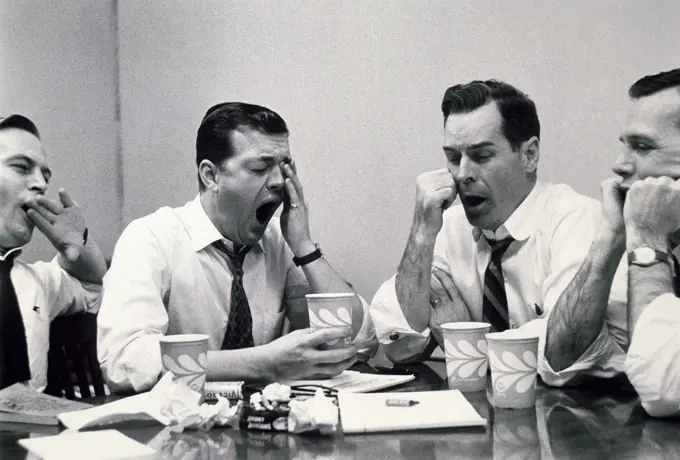 Close-up of four businessmen yawning