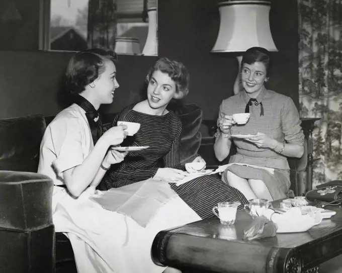 Three young women drinking tea