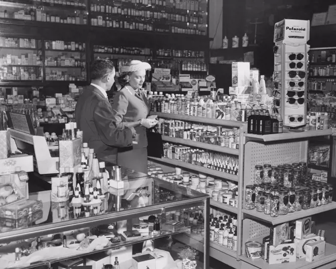 Side profile of a salesman standing with a customer in a store