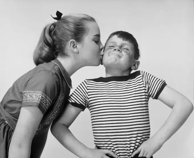 Close-up of a sister kissing her brother