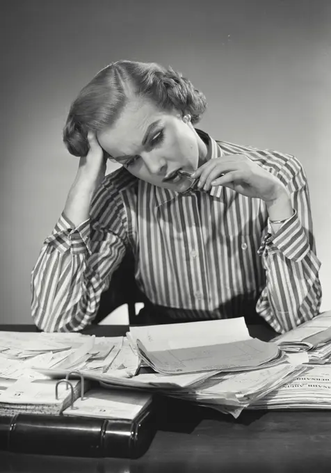 Vintage Photograph. Woman in striped collared blouse with head on hands in thought