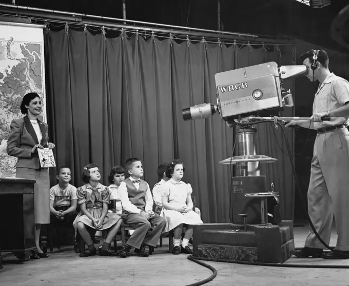 Group of children and a woman performing in a television studio