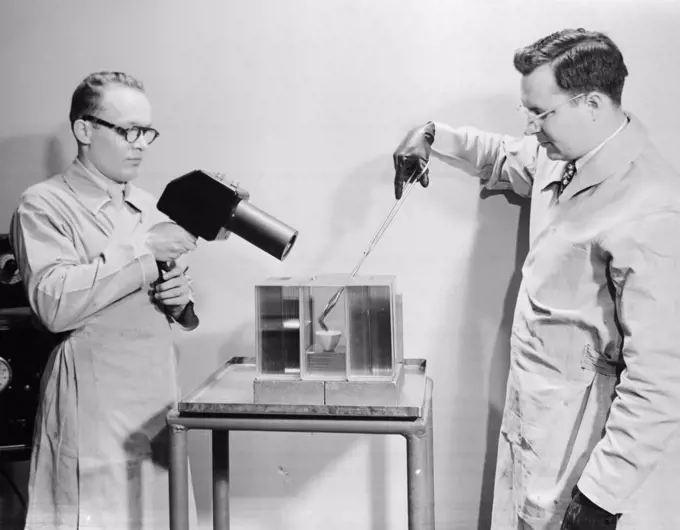 Side profile of two scientists experimenting in a laboratory, PPG Industries