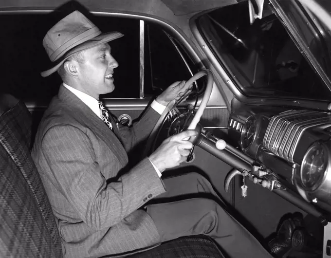 Side view of mature man sitting inside of car