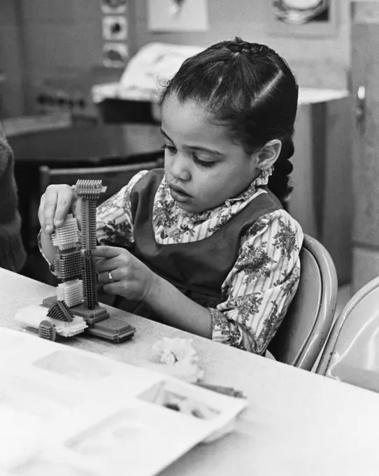 Schoolgirl playing with blocks in a classroom