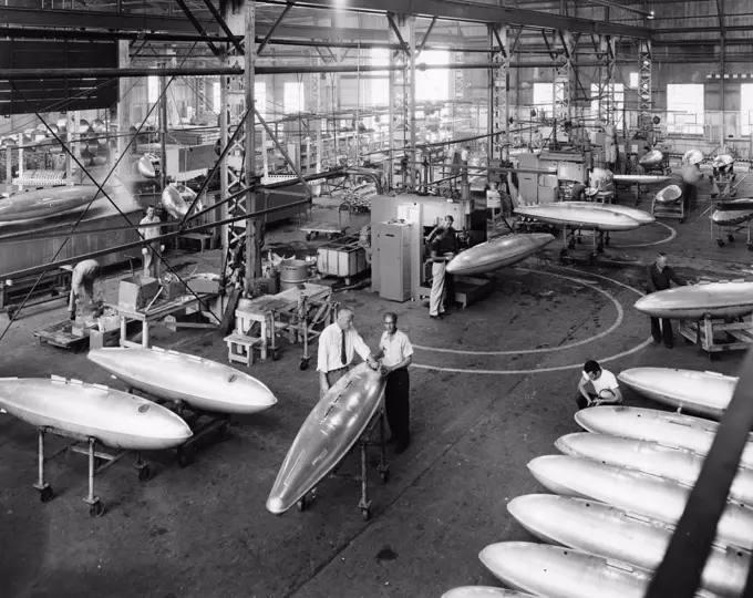 Technicians manufacturing fuel tanks for fighter planes