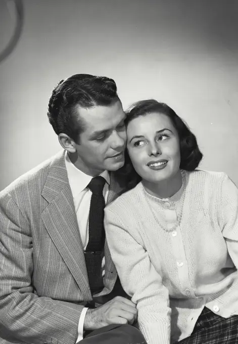 Vintage photograph. Portrait of male/female couple sitting holding faces close together