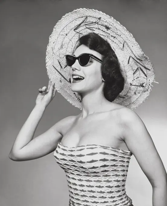 Young woman wearing a straw hat on the beach