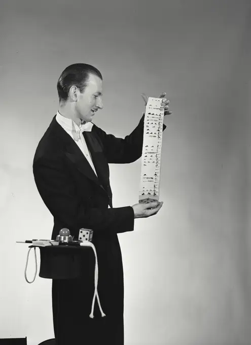 Vintage Photograph. Side profile of a magician performing a card trick