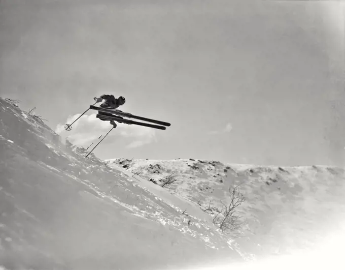 Vintage photograph. Skiing at Tuckerman Ravine on Mt. Washington. Skier jumping in air above the snow.