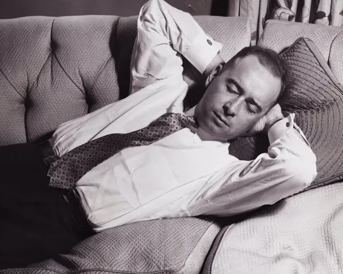 Close-up of a mid adult man sleeping on a couch