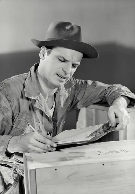 Vintage photograph. Focused working man looking at clipboard