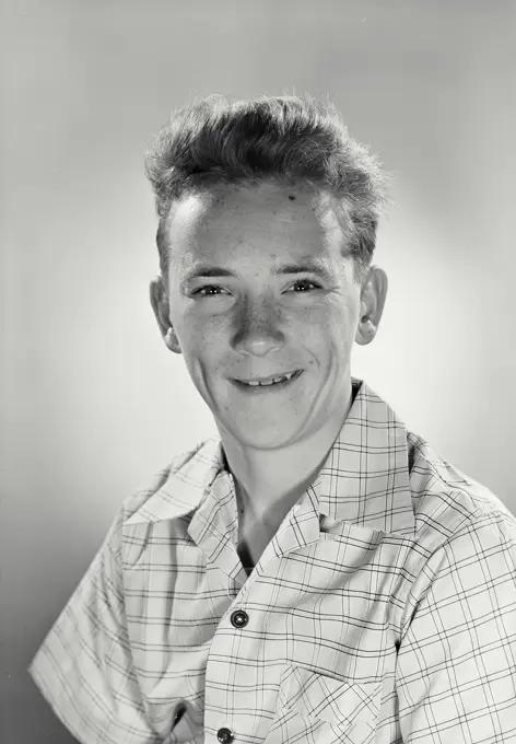 Vintage photograph. Young man in button smiling shirt looking at camera