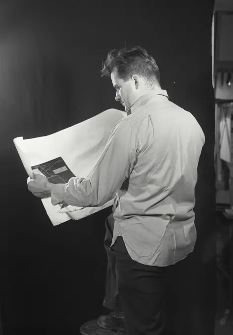 Vintage photograph. Man looking at blueprint