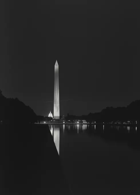 Vintage photograph. Night view of the Washington Monument and Capitol Dome and reflection in pool