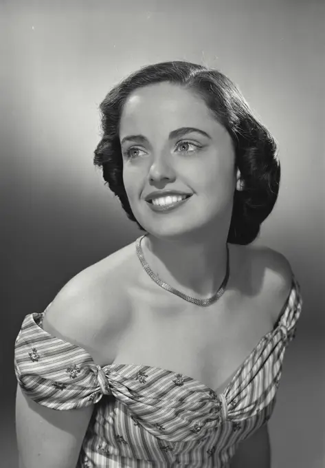 Vintage photograph. woman in strapless dress looking away from camera.