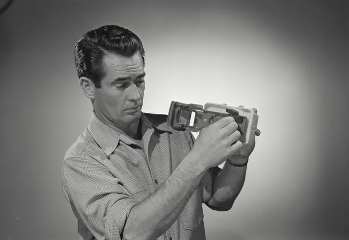 Vintage photograph. man in button shirt holding toy truck