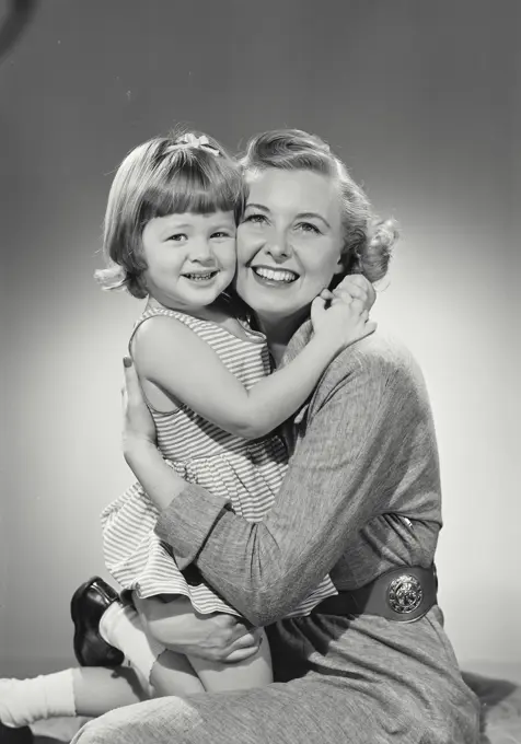 Vintage photograph. Mother and daughter hug each other and smile