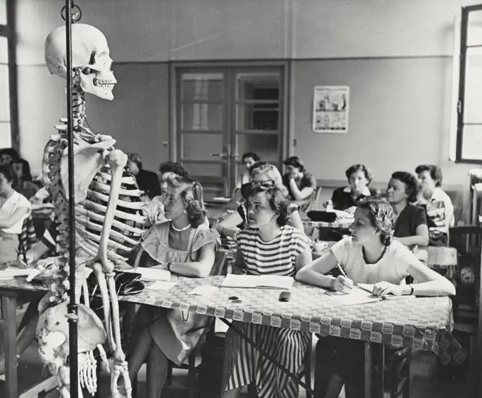 Vintage photograph. Refresher course on anatomy is given to nurses studying physical rehabilitation of crippled children