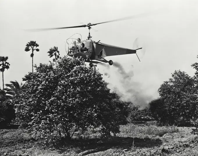 Vintage photograph. Bell helicopter performing Black fly fogging operations