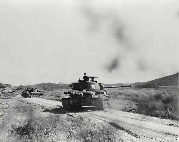 Vintage photograph. Units of a tank battalion move down the road to support infantrymen attempting to rout Communist positions on a hill in Korea