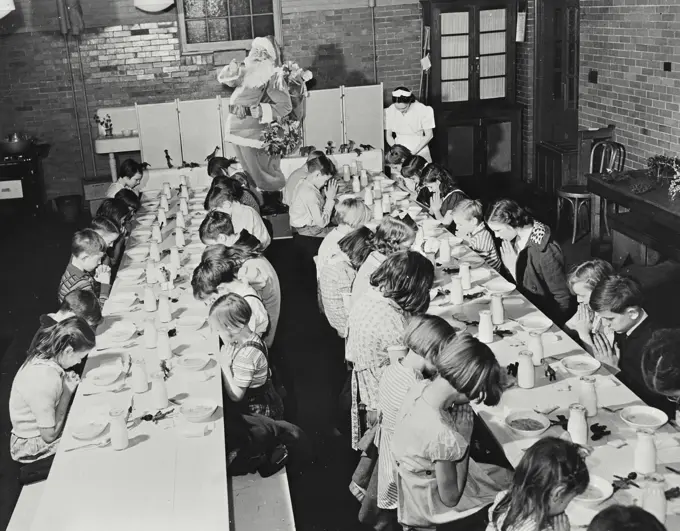 Vintage photograph. Public school children in Washington DC giving thanks for their daily lunch