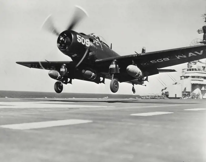 Vintage photograph. A Navy "Skyraider" armed with three 1,000 pound bombs takes off from the USS Valley Forge